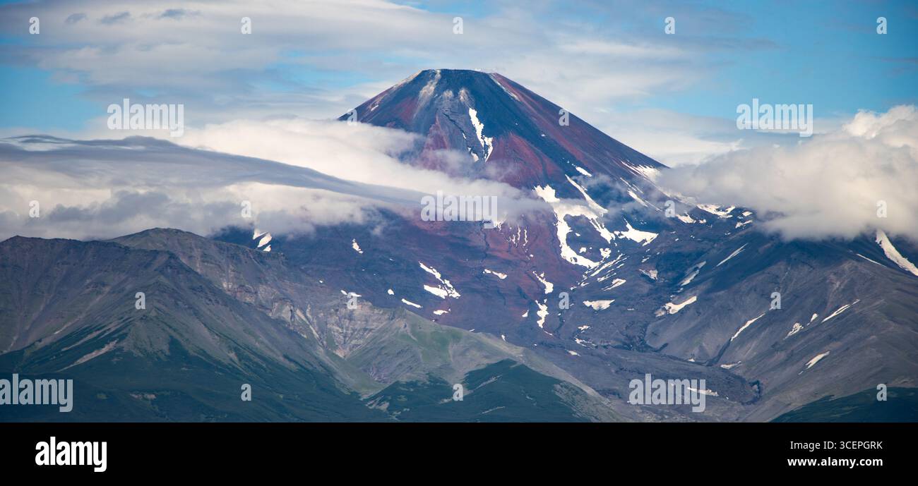 Il vulcano Avachinsky circondato da nuvole nella Kamchatka, il maestoso paesaggio vulcanico della Russia, è ideale per il turismo e la fotografia naturalistica Foto Stock