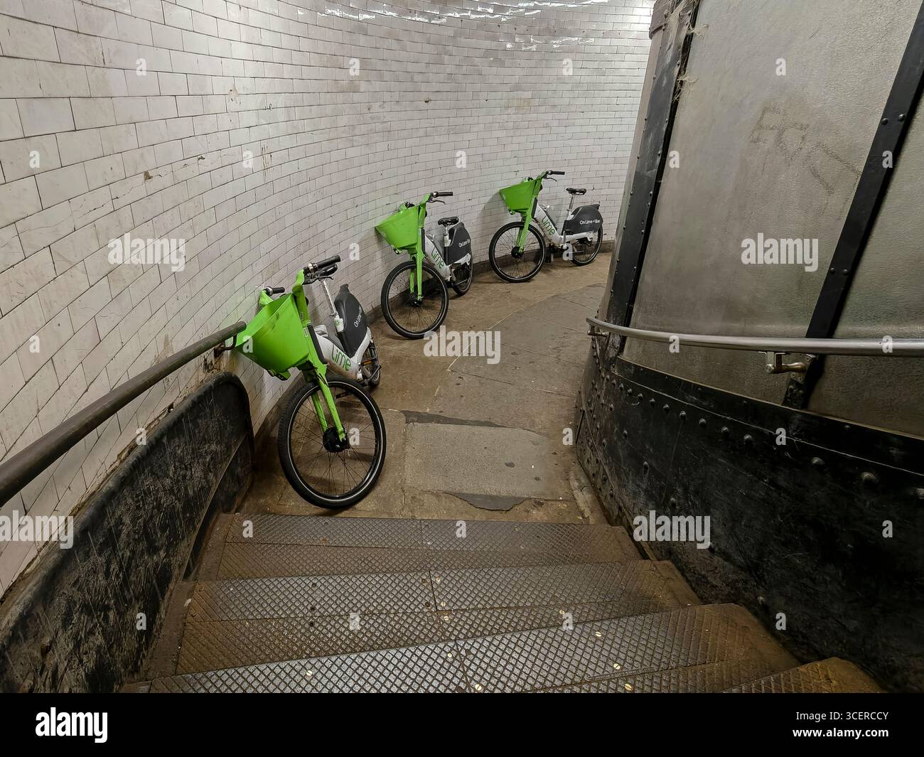 Londra, Regno Unito. 19 agosto 2025. I cicli di noleggio delle calce abbandonati sono stati scaricati ai piedi delle scale del tunnel pedonale di Greenwich, sotto il Tamigi, tra Cutty Sark a sud e Island Gardens a nord, presumibilmente perché i cavalieri li trovavano troppo pesanti per salire le scale fino in superficie. Anche se all'esterno e all'interno del tunnel ci sono molti segnali che dicono "No Cycling", ci sono quelli che ignorano la sicurezza dei pedoni. Crediti: Stephen Chung / Alamy Live News Foto Stock
