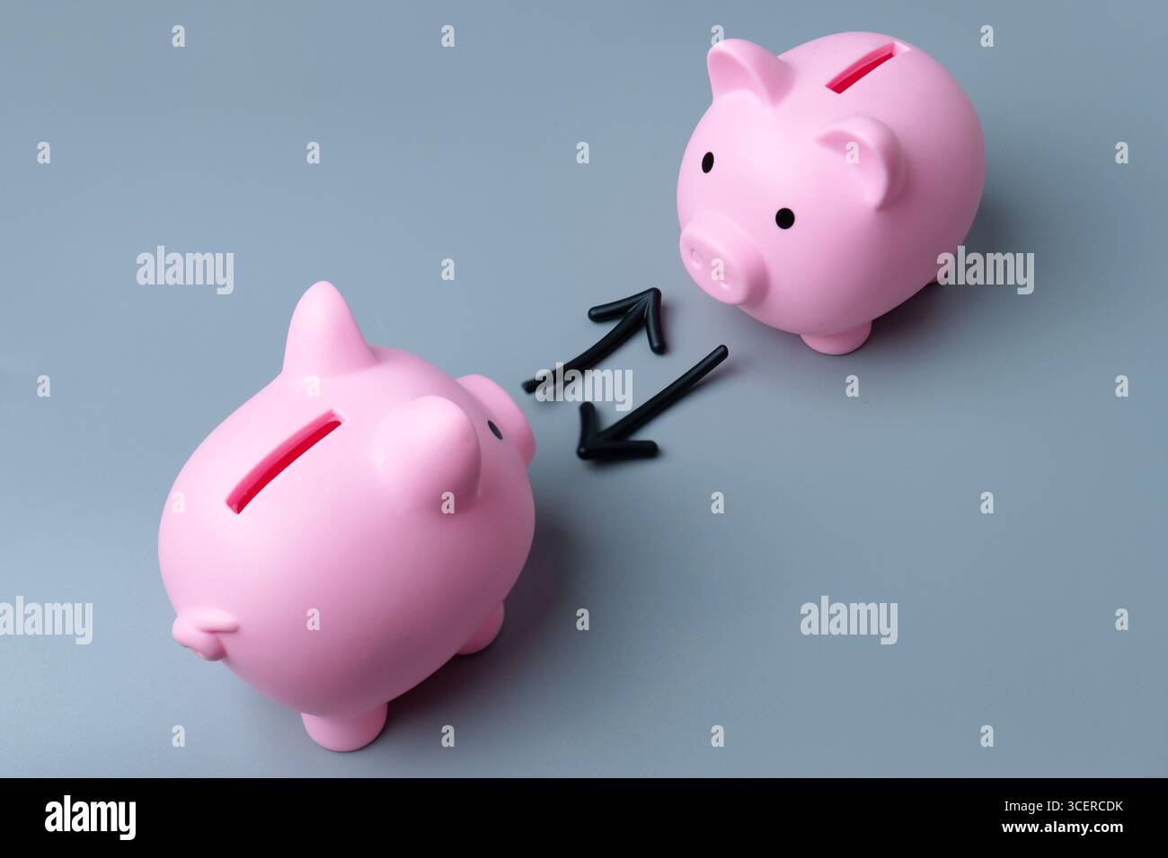 Due salvadanaio e frecce che simboleggiano uno scambio o un trasferimento. Scambio o negoziazione di attività all'interno di un concetto di fondo. Foto Stock
