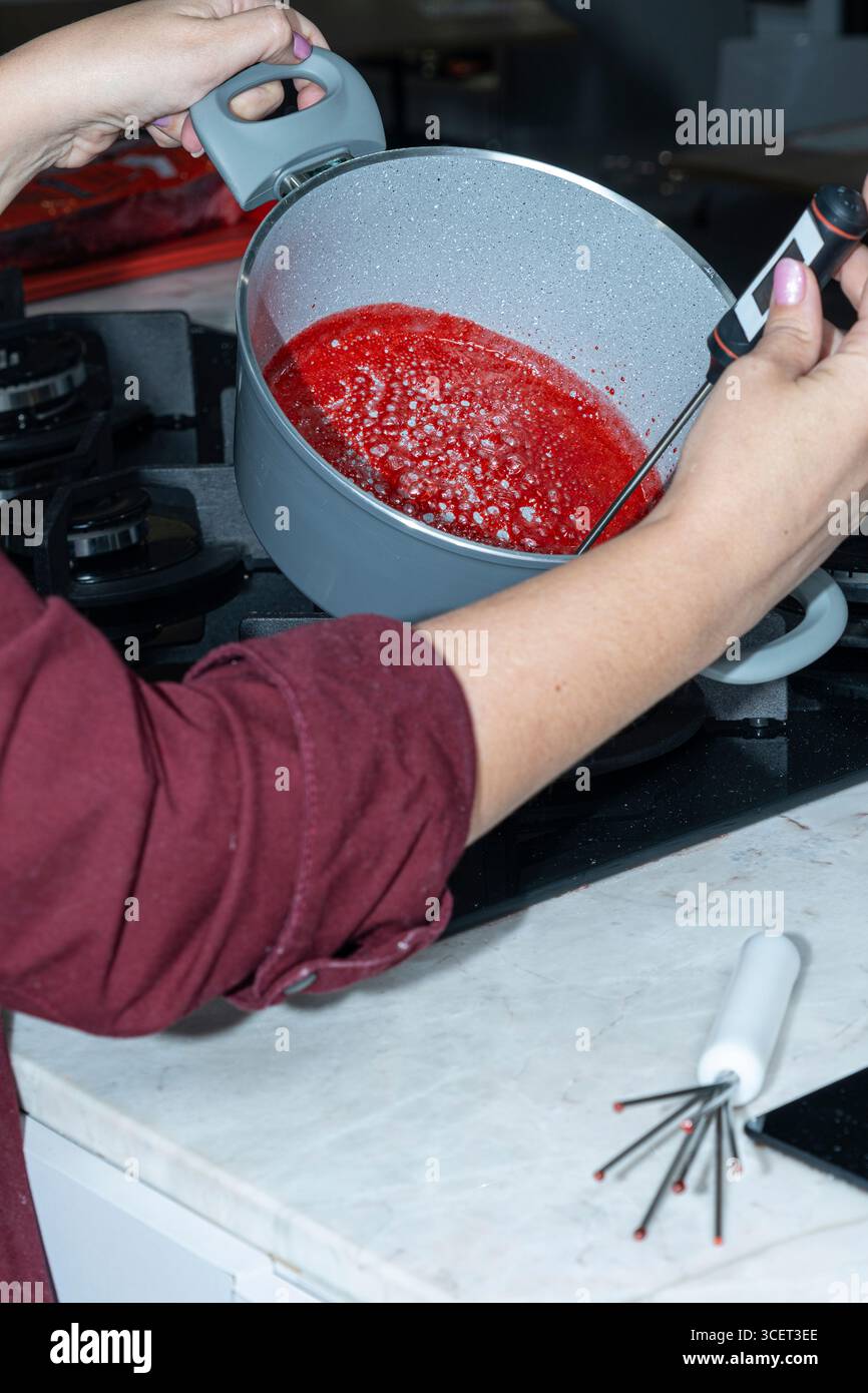 Chef che misura la temperatura della topping Vertical dei frutti di bosco. Foto Stock