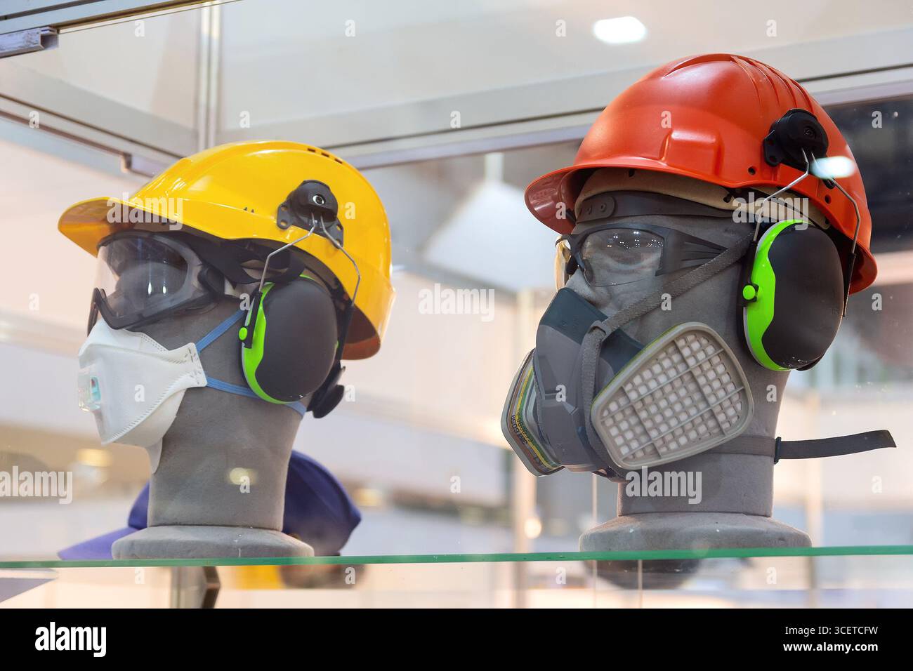 Manichini in casco, occhiali di sicurezza, cuffie e respiratore nello showroom. Protezione del lavoro Foto Stock