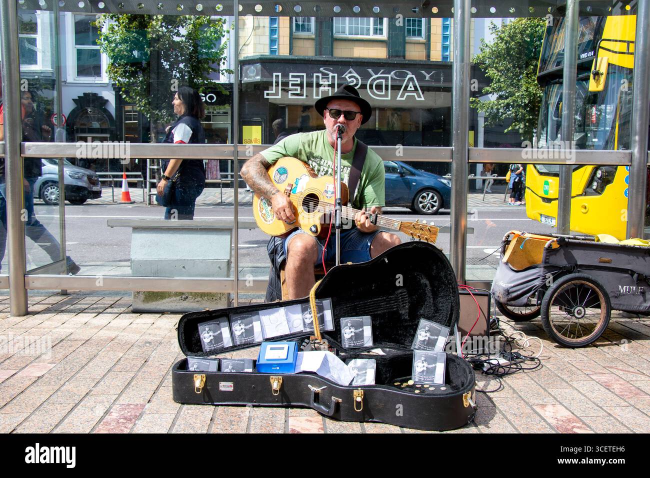 Busker che suona la chitarra a Patrick Street, Cork City, Irlanda Foto Stock