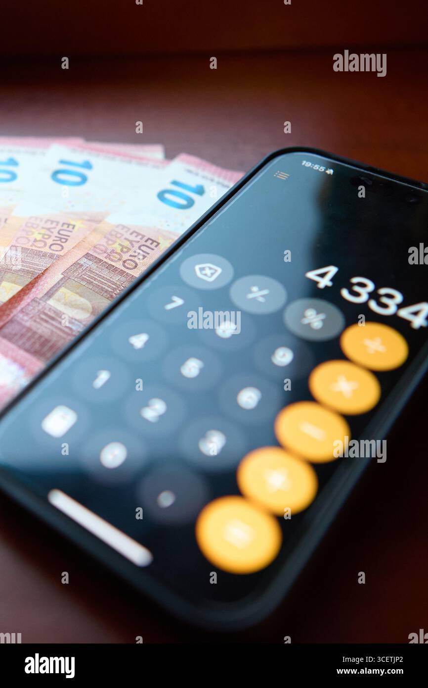 Calcolatrice collocata su banconote in euro al banco Foto Stock