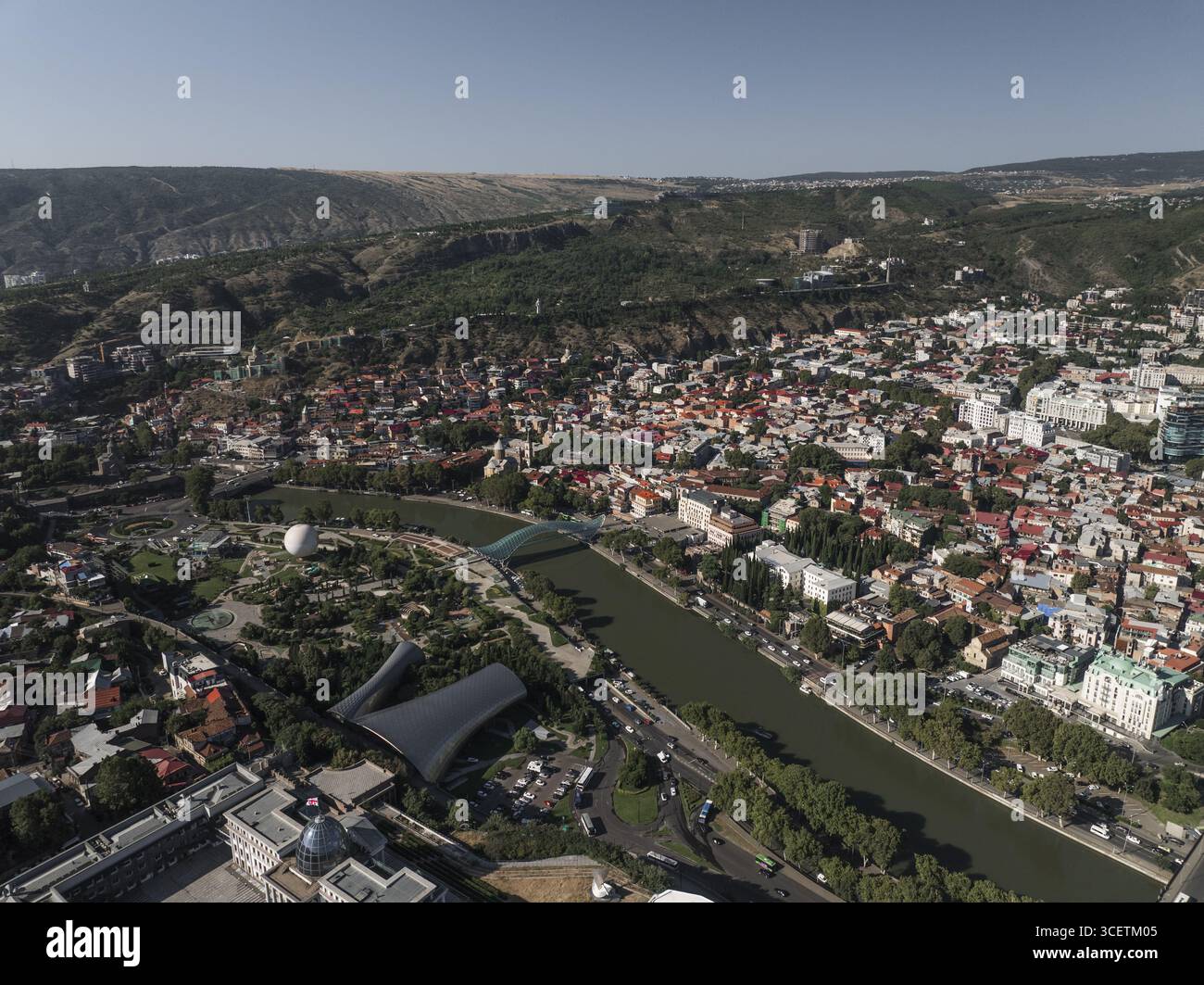 Vista aerea del tortuoso fiume Mtkvari che riflette il cielo, tagliando attraverso il cuore della città vicino al Rike Park e al Ponte della Pace, Tbilisi, Tbilisi, Georgia. Foto Stock