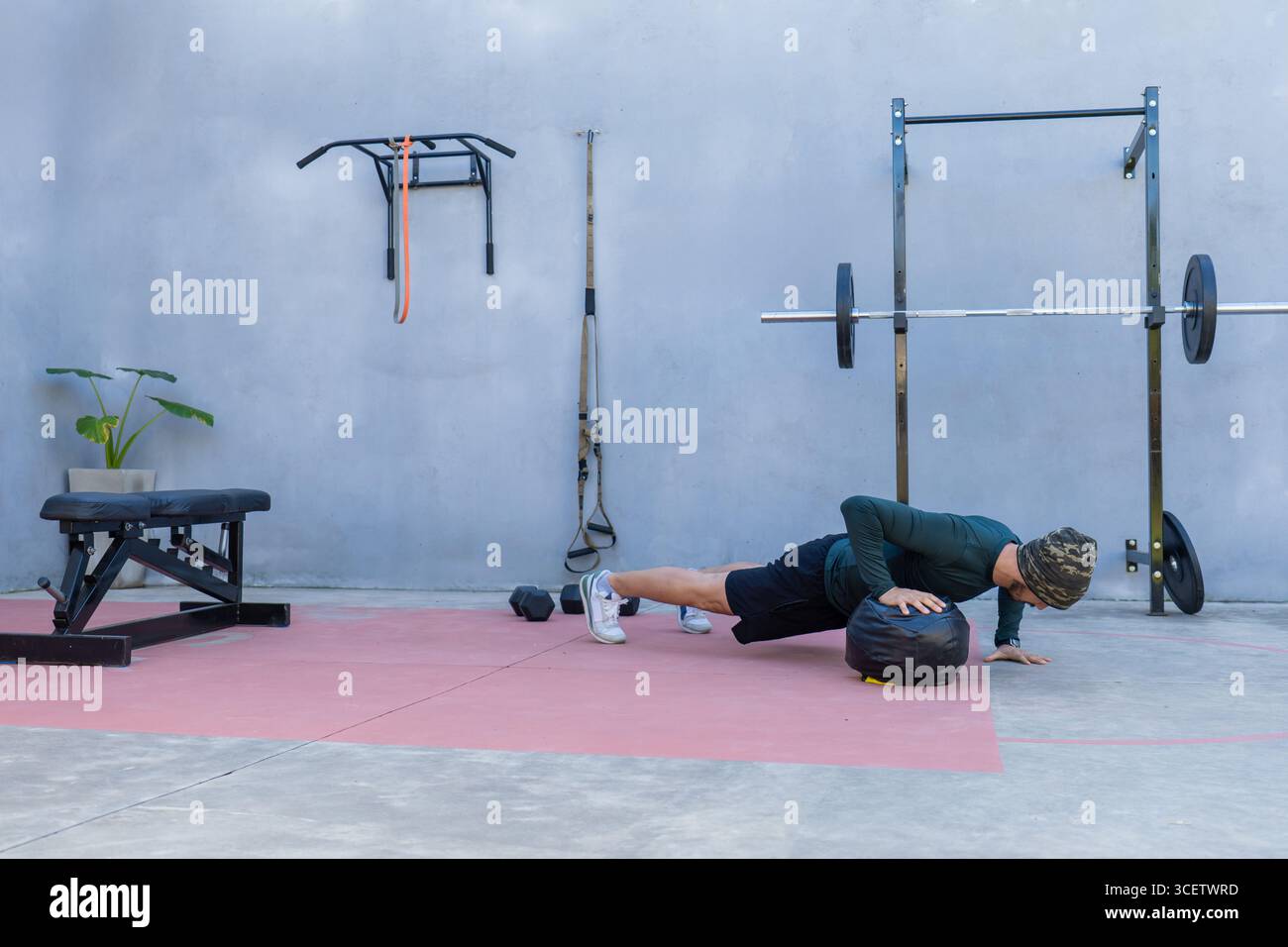 Giovane atleta che esegue push-up con le mani su una palla medica in una palestra all'aperto, mostrando forza e fitness mentre abbraccia una forma attiva e curativa Foto Stock