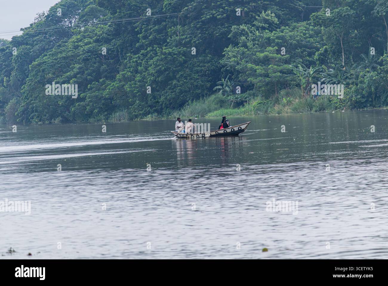 trasporto fluviale rurale con barca in legno che attraversa tranquilli dintorni naturali Foto Stock