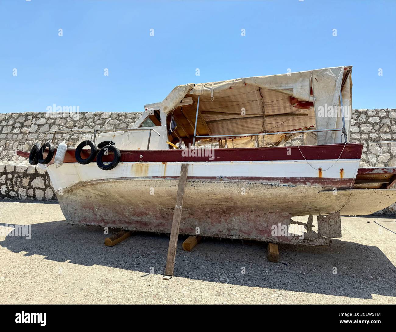 Turkiye, Antalya, molo di Finike. Una vecchia barca logora con fondo arrugginito e fangoso si appoggia sulla riva. Un ricordo delle avventure passate - Immagine stock catturata con smartphone