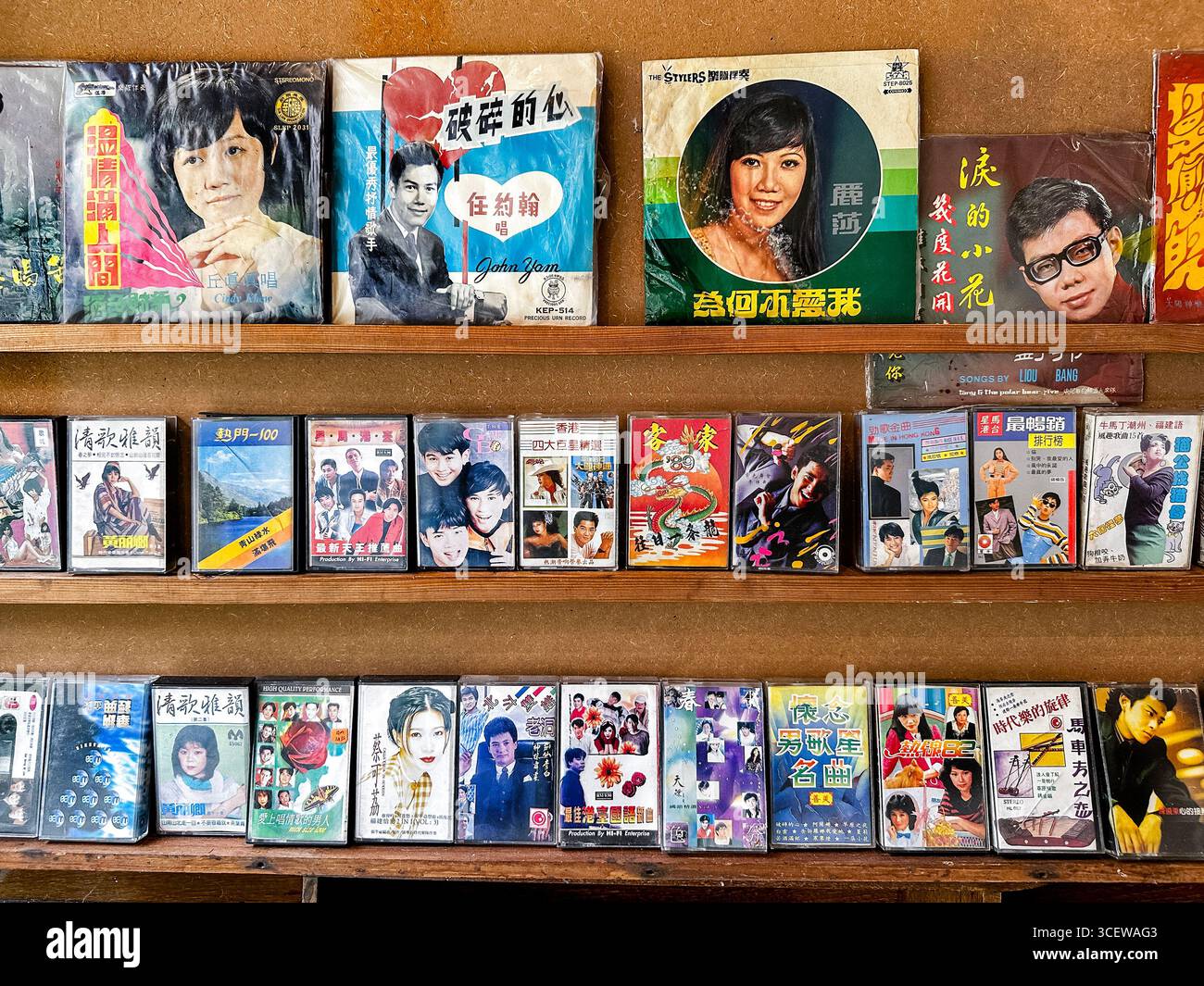 Mostra rétro di dischi in vinile cinese vintage e cassette su scaffali in legno che mostrano le star della musica popolare del passato Malacca malesia - Immagine stock catturata con smartphone