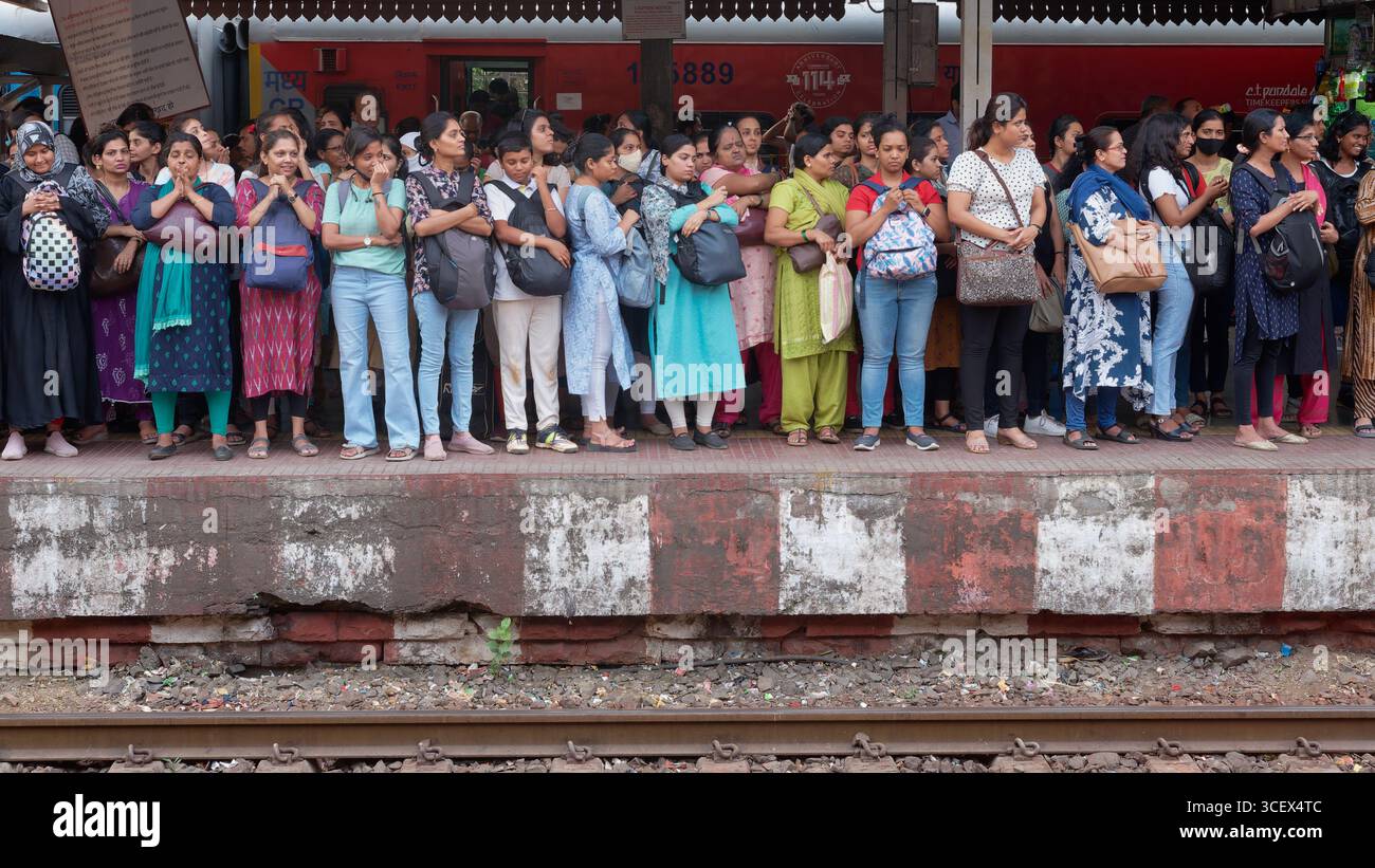 Un mucchio di pendolari che affollano una piattaforma alla stazione di Dadar a Mumbai, in India, in attesa di salire a bordo di uno dei carrelli speciali per donne Foto Stock