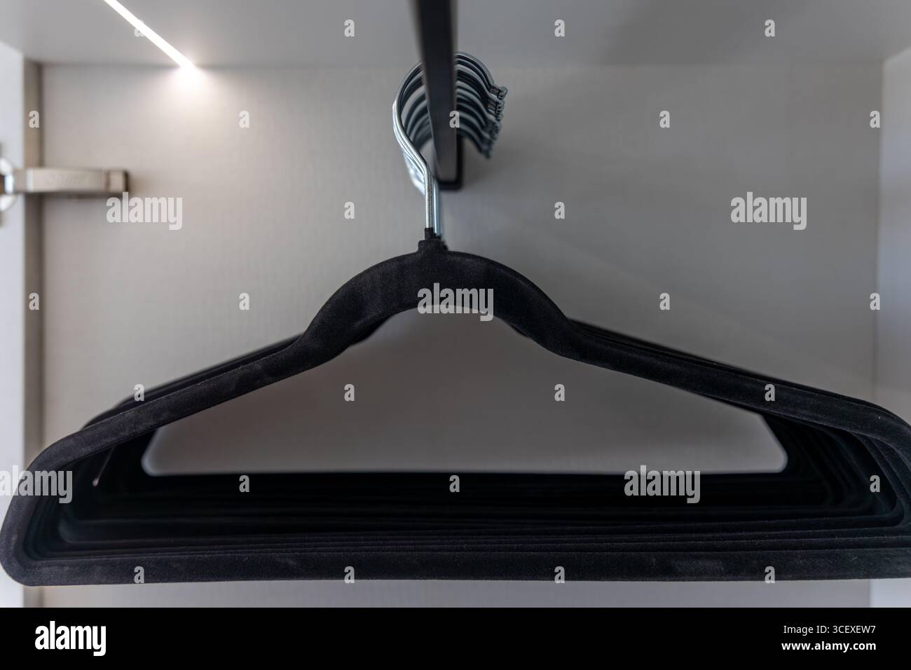 Primo piano dell'appendiabiti. Armadio a muro con luce LED. Guardaroba premium. Foto Stock