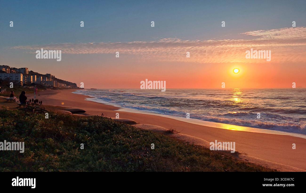 Alba sull'Oceano Indiano a Umdloti Beach, KwaZulu-Natal, Sud Africa, con onde che si infrangono sulla costa dorata. - Immagine stock catturata con smartphone