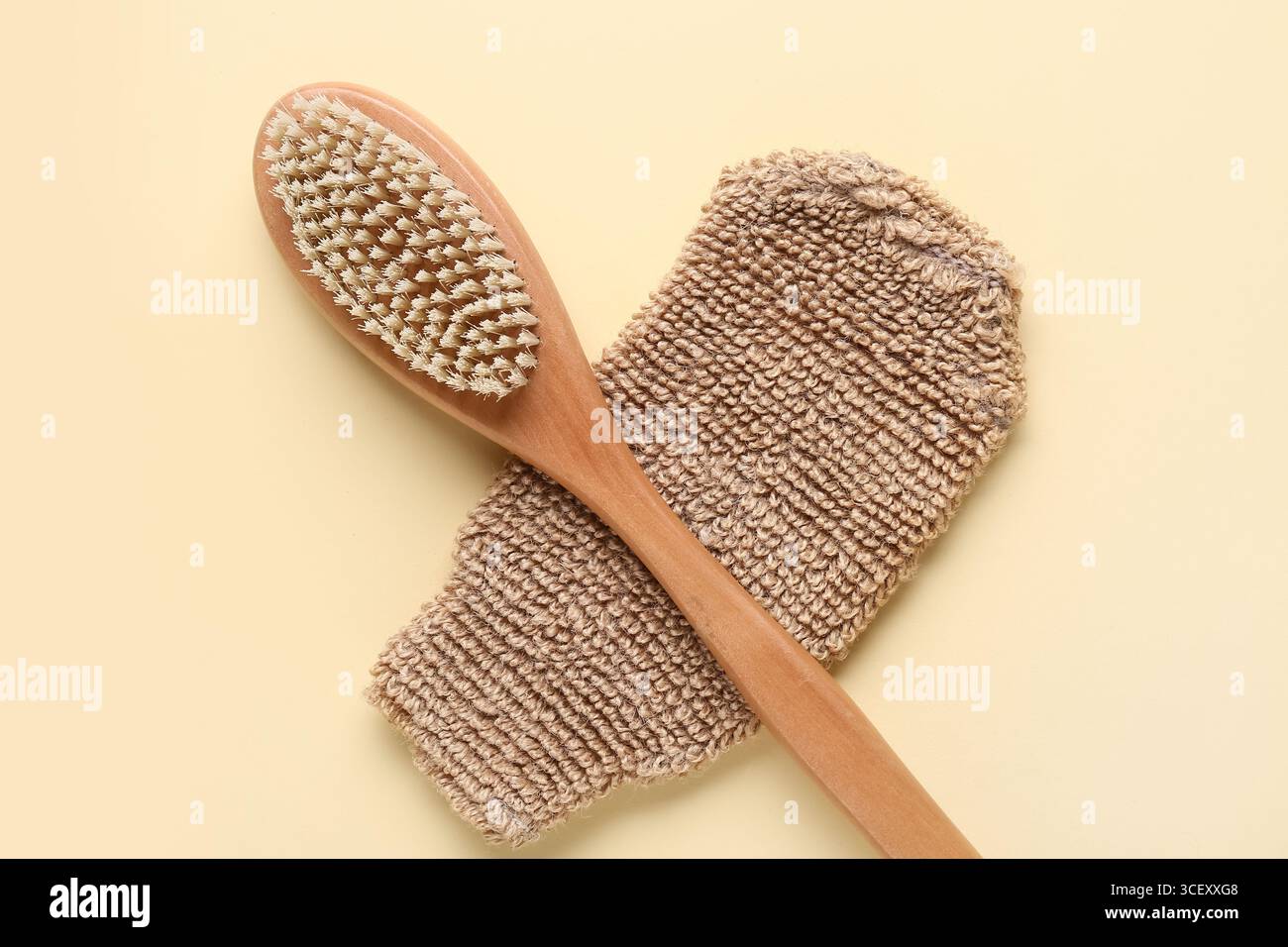 Composizione con guanto massaggiante e spazzola corpo massaggiante su sfondo beige, primo piano Foto Stock