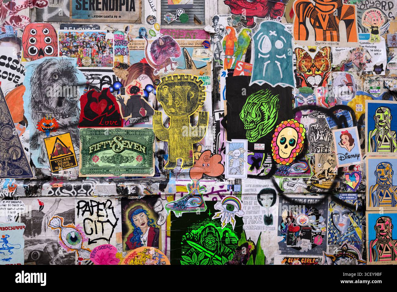 Porte coperte da poster in pasta di grano Street art, Fournier Street, Londra, Regno Unito. 12 giugno 2025 Foto Stock