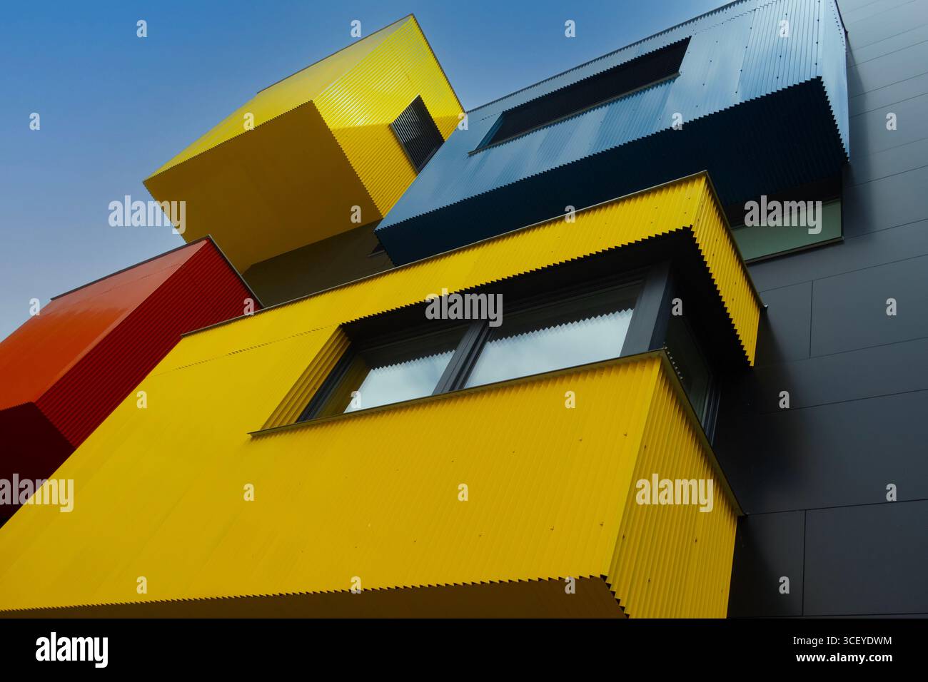 Moderno edificio residenziale con coloratissimi elementi geometrici della facciata in giallo, rosso e blu Foto Stock