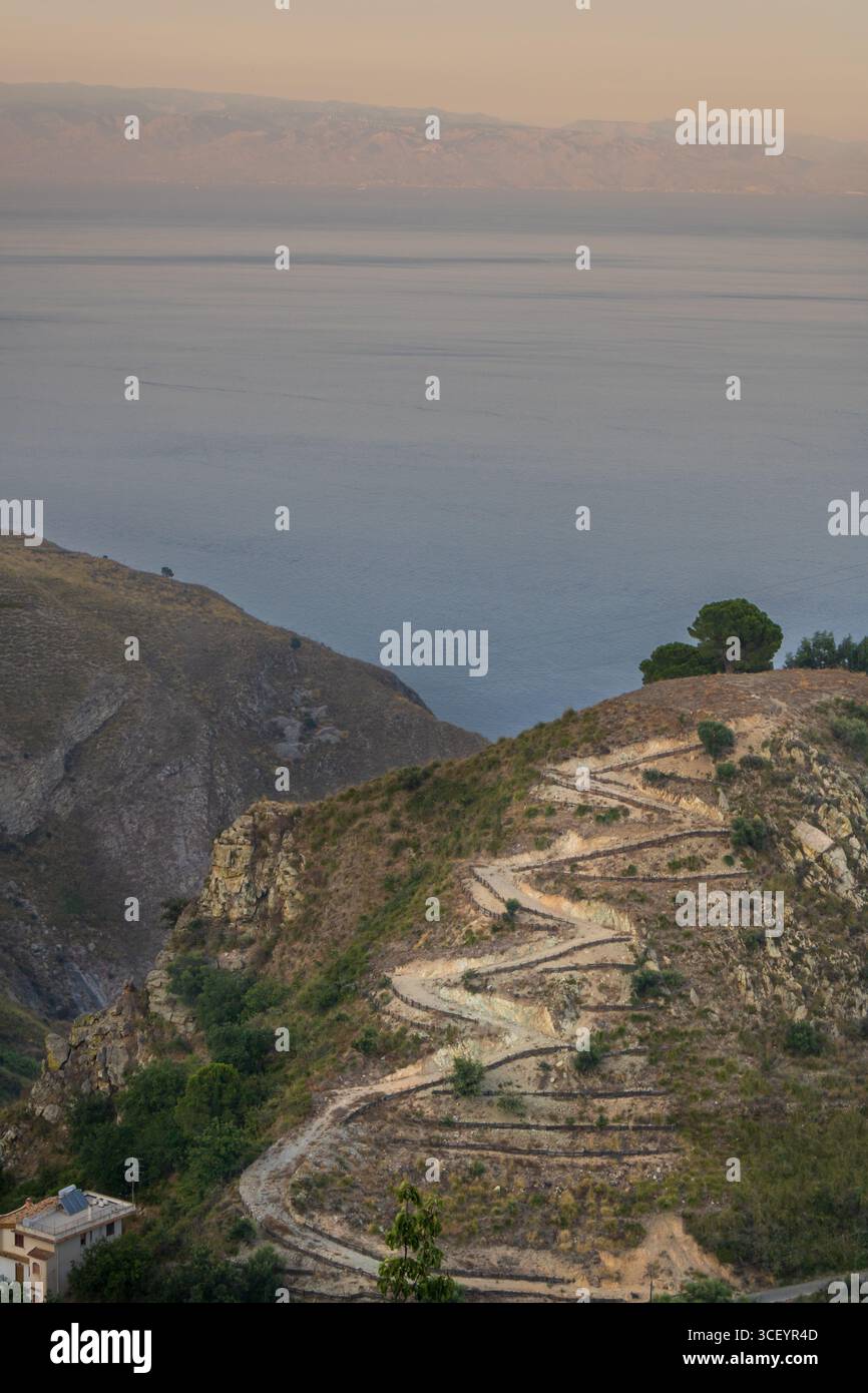 I sentieri tortuosi del sentiero di Castelmola rivelano ampie vedute della costa siciliana Foto Stock