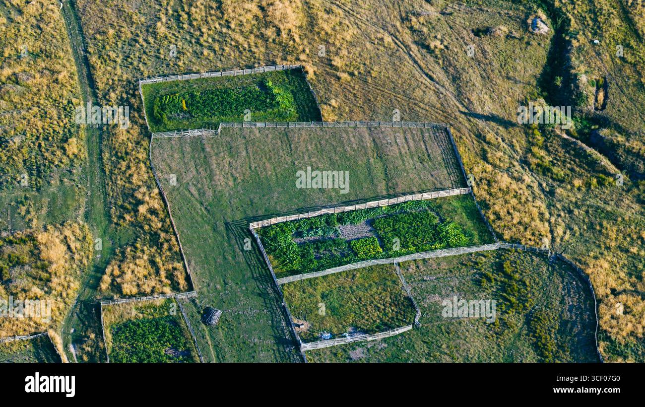 I motivi geometrici del giardino incorniciati da recinzioni rustiche offrono uno sguardo sulla vita rurale semplice Foto Stock