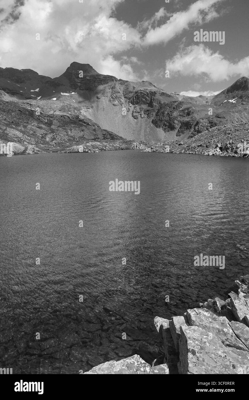 Vista monocromatica del lago di montagna e aspre vette alpine vicino al Monte bianco in un contrasto drammatico Foto Stock