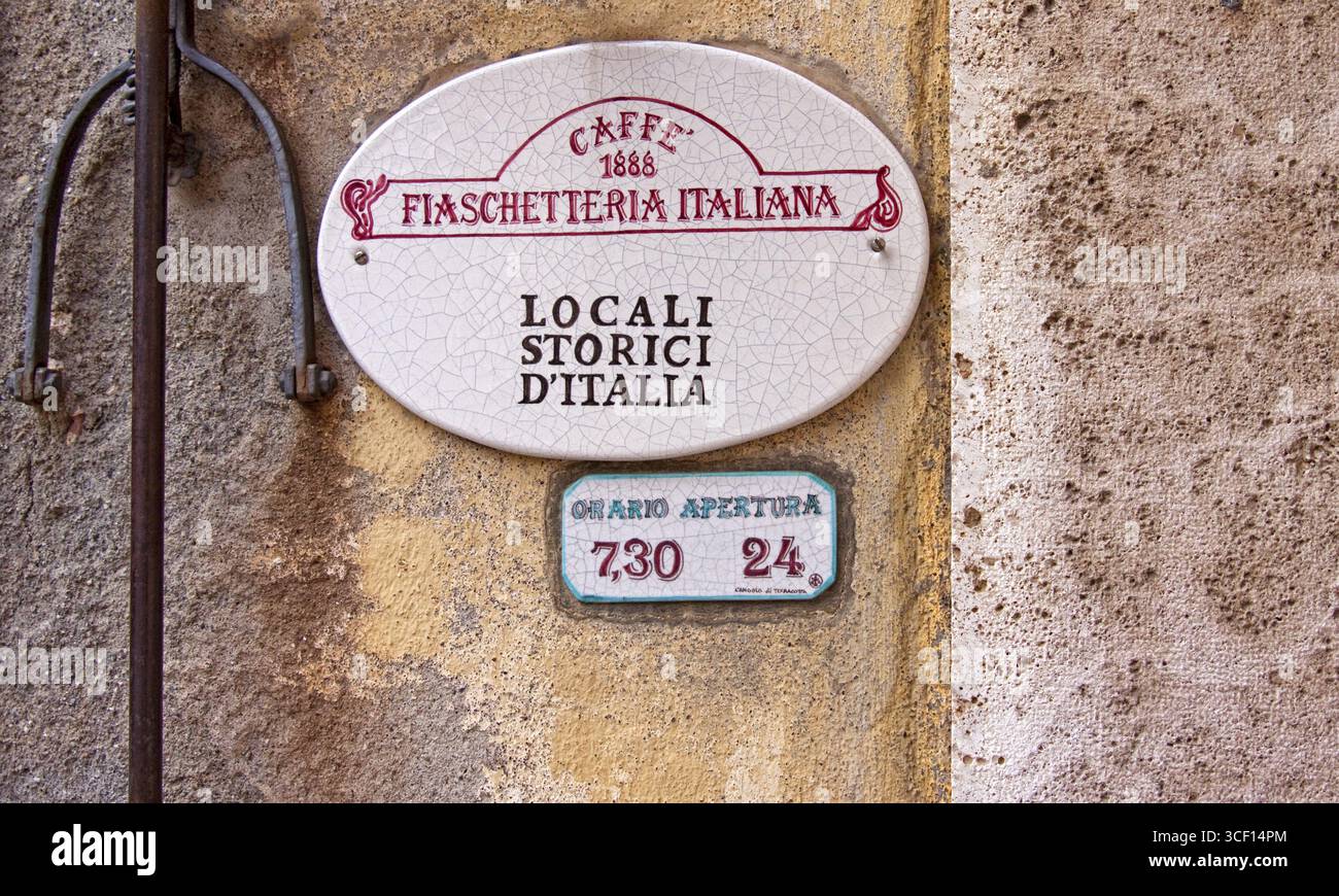 Un segno rustico di un caffè italiano su una parete con riferimenti a luoghi storici, Montalcino, Toscana, Italia Foto Stock