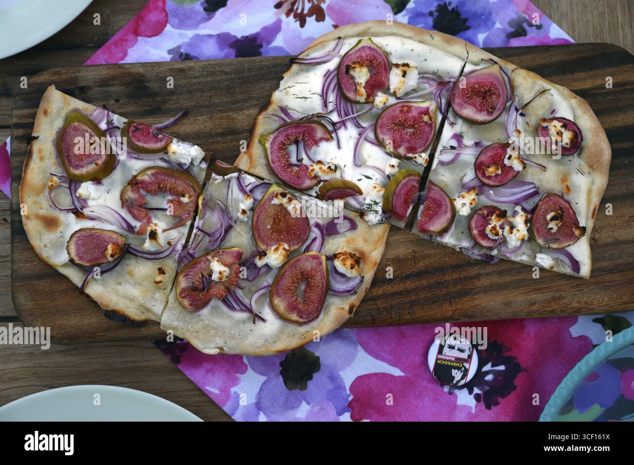 Tarte flambee con fichi freschi, cipolle e formaggio di capra servito su un tagliere di legno, Baden-Wuerttemberg, Germania Foto Stock