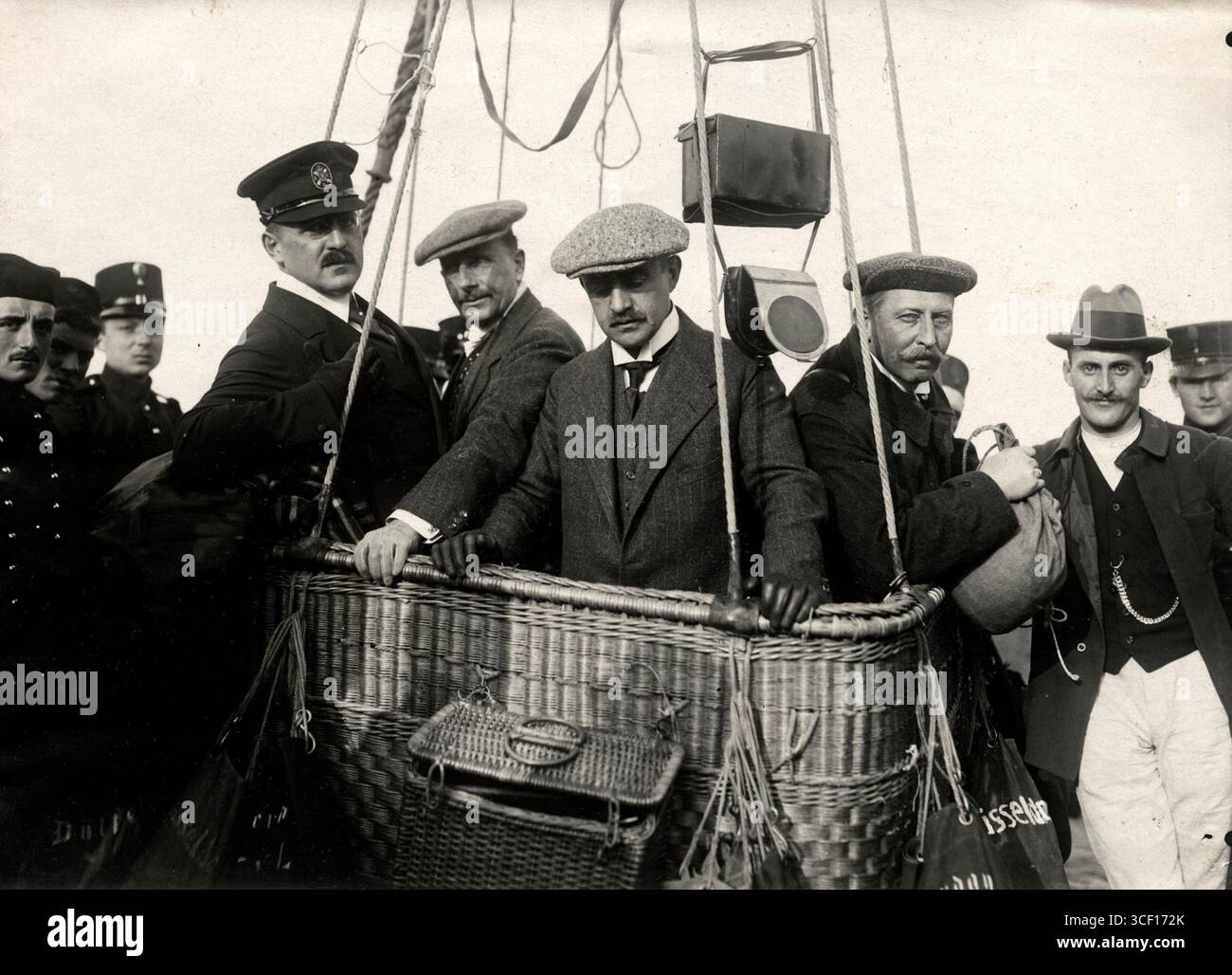 Questa foto del 1912 mostra un equipaggio di palloncini nel loro cesto durante la gara di caccia alla volpe in mongolfiera a l'Aia, nei Paesi Bassi. L'evento ha attirato numerosi appassionati di palloncini ed è stato una parte importante della cultura aeronautica olandese. Foto Stock