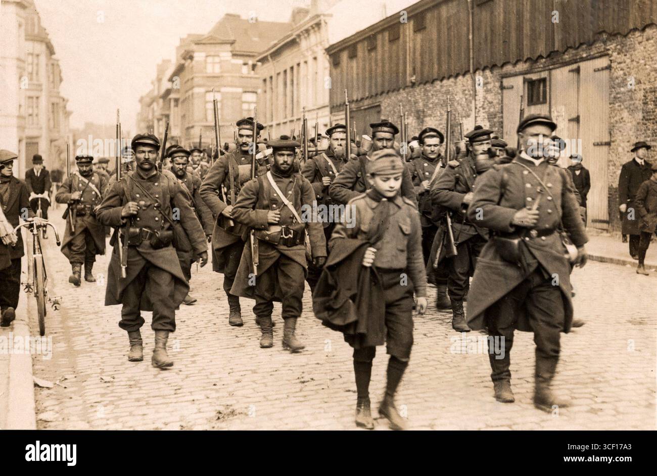 In questa immagine del 1914, i marines francesi assistono i soldati belgi in un villaggio francese durante la prima guerra mondiale, guidati da un esploratore francese che li dirige sul campo di battaglia. Foto Stock