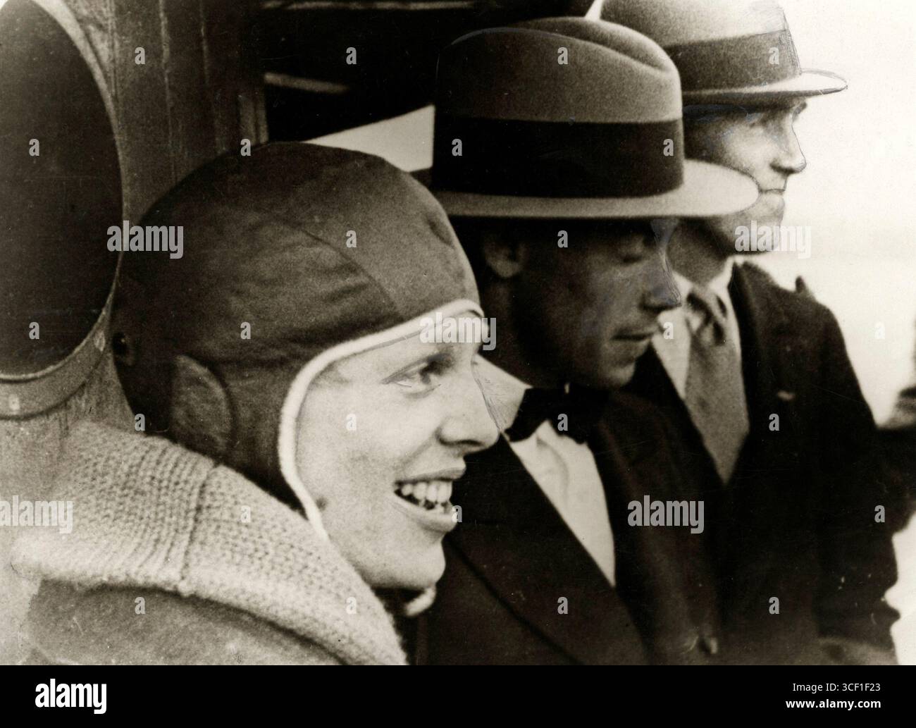 Nel 1928, l'aviatrice americana Amelia Earhart viene fotografata indossando un cappellino da volo accanto a due uomini. Fu uno dei pionieri più famosi dell'aviazione all'inizio del XX secolo. Foto Stock
