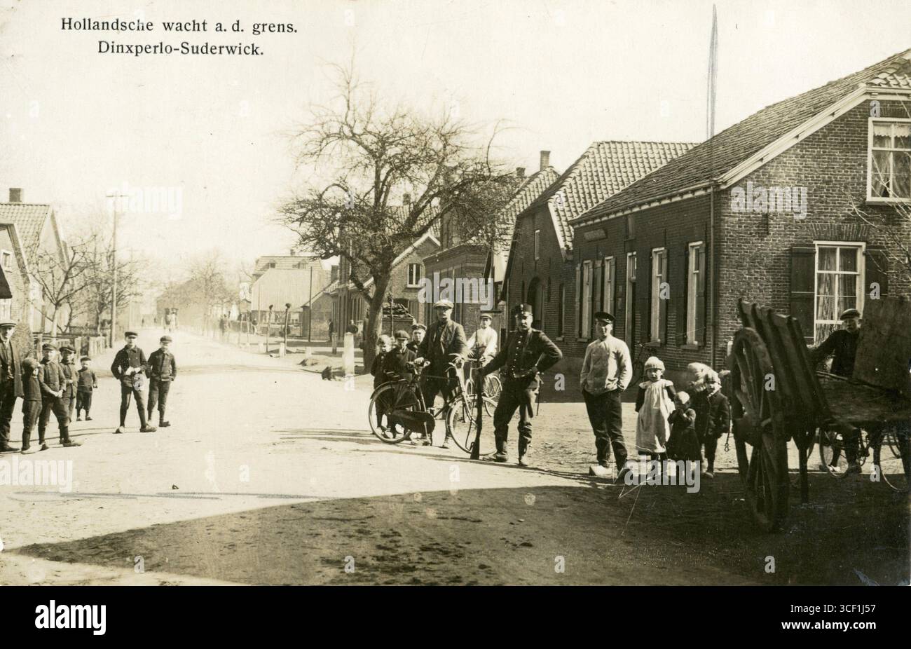 Una cartolina propagandistica della prima guerra mondiale che mostra una guardia di frontiera olandese a Dinxperlo-Suderwick, dove scorre il confine tra Paesi Bassi e Germania lungo la strada. I bambini con scarpe di legno sono mostrati in piedi vicino alla Germania. Data sconosciuta (probabilmente prima del 1918). Foto Stock