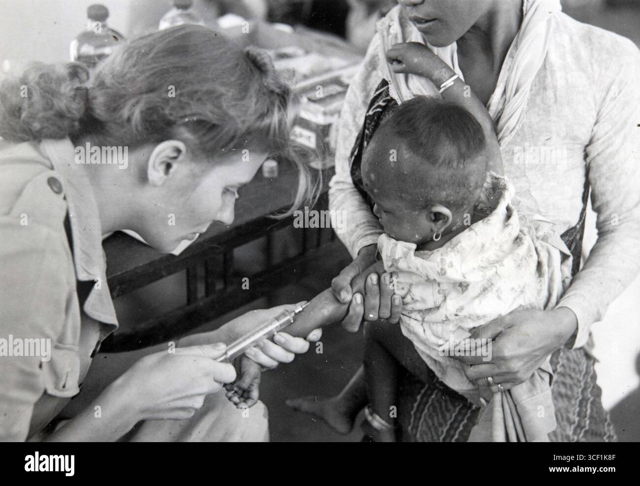 Questa foto mostra Suor Edemaker della Croce Rossa che fa un'iniezione a Taroekan vicino Pekalongan a un bambino indonesiano. Il team della Croce Rossa forniva assistenza medica due volte a settimana nella zona durante il periodo 1945-1950. Foto Stock