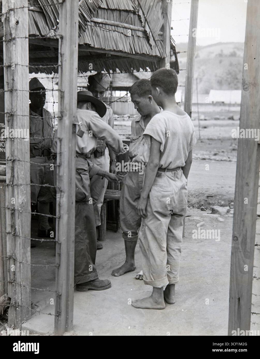 Questa fotografia del 1945-1950 mostra due prigionieri giapponesi catturati ad Arso (nuova Guinea) in attesa delle autorità americane a Kota Nica. La foto riflette il periodo post-seconda guerra mondiale e il destino dei prigionieri di guerra giapponesi nella regione. Foto Stock