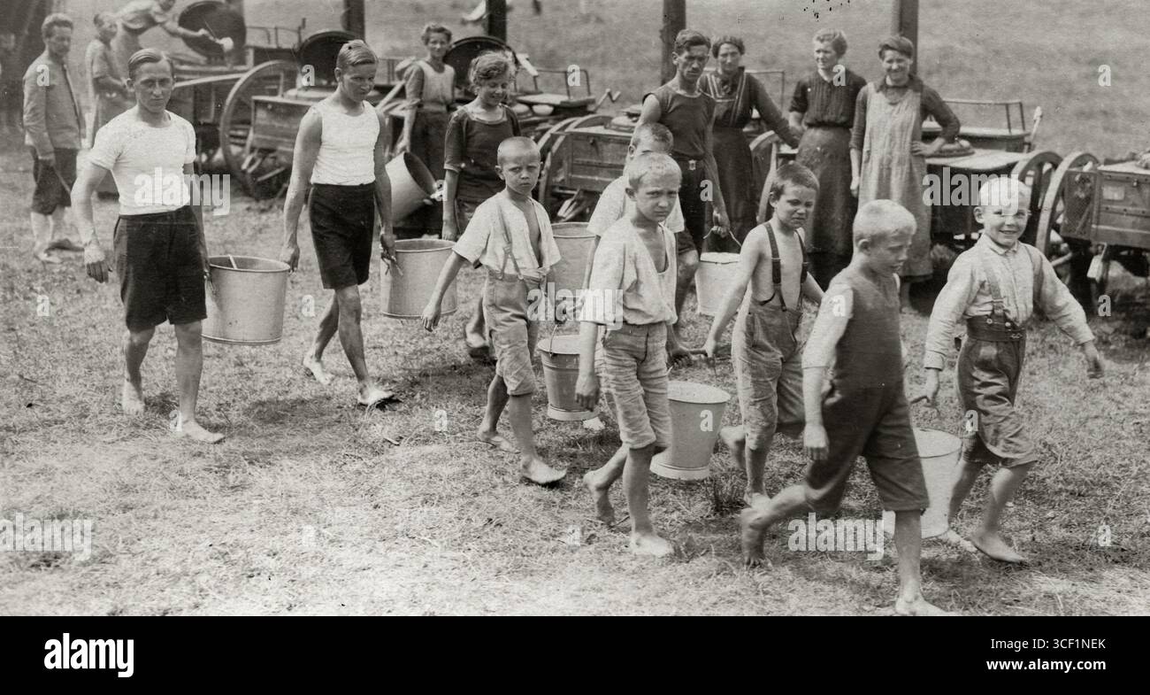 Nel 1919, i bambini tedeschi malnutriti sono visti trasportare secchi di cibo dopo che il blocco è stato revocato, segnando la fine delle carenze alimentari causate dalla prima guerra mondiale Foto Stock