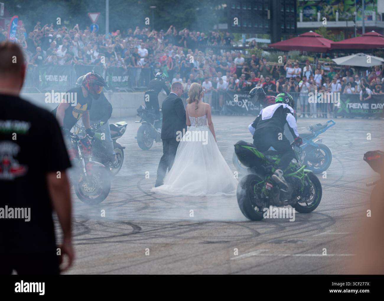 I piloti acrobatici bruciano le gomme intorno agli sposi alla festa della moto a Banja Luka, sposa e sposo in fumo Foto Stock