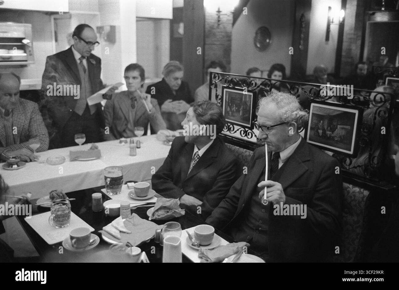 Uomini che fumano tradizionali pipe di argilla Churchwarden all'Old Duncow Inn. Tradizionale colazione in comune annuale dopo la cerimonia d'argento Wroth. Stretton on Dunsmore, Warwickshire Inghilterra 1975 1970s UK HOMER SYKES Foto Stock