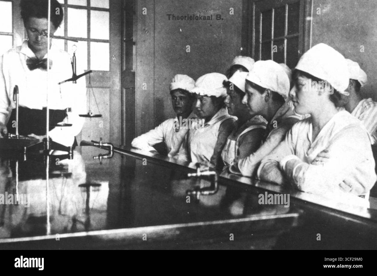 Il "Theorielokaal B" (aula teorica) della Rotterdam Household School sulla seconda Middellandstraat, fotografato nel 1920, fornisce uno spazio per l'educazione teorica nella scienza domestica. Foto Stock