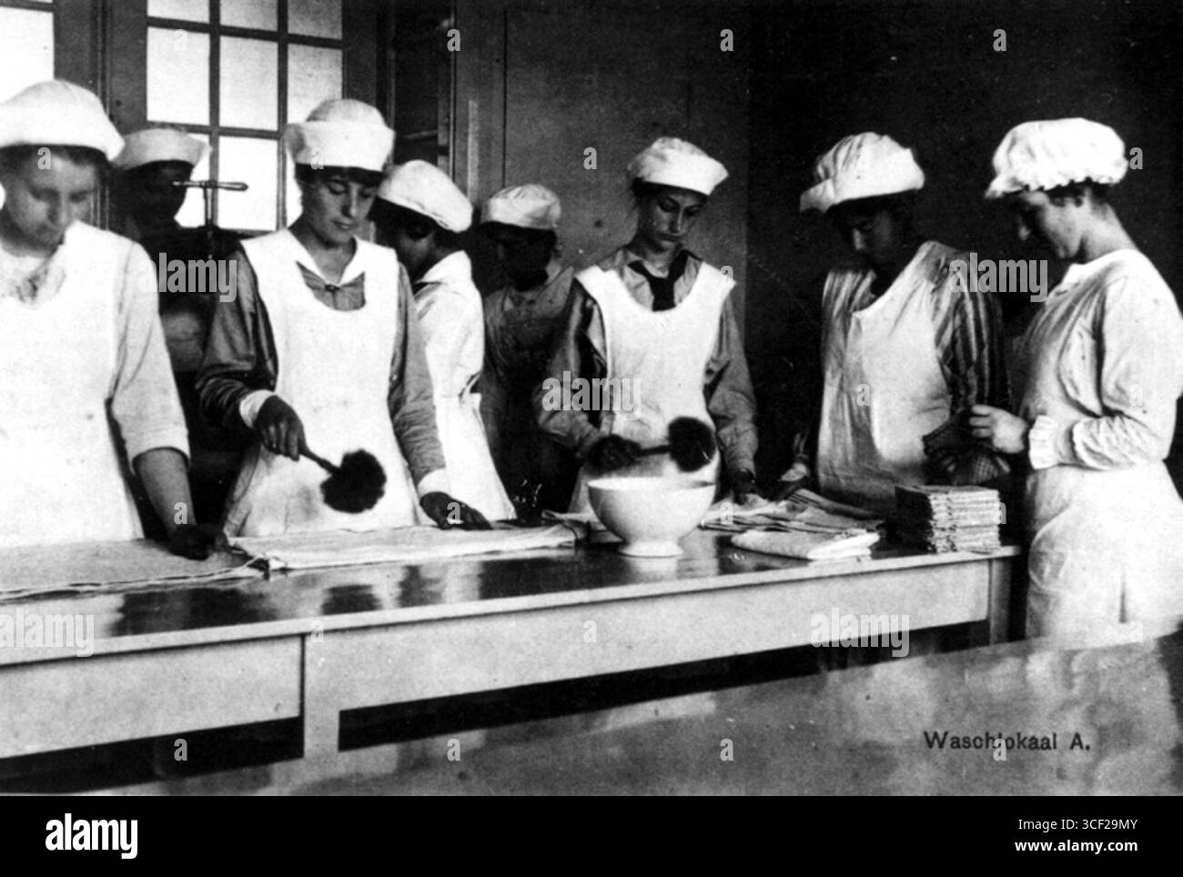 La lavanderia ("Waslokaal A') della Rotterdam Household School, situata nella seconda Middellandstraat, fotografata nel 1920, illustra l'ambiente pratico di apprendimento per l'educazione domestica. Foto Stock