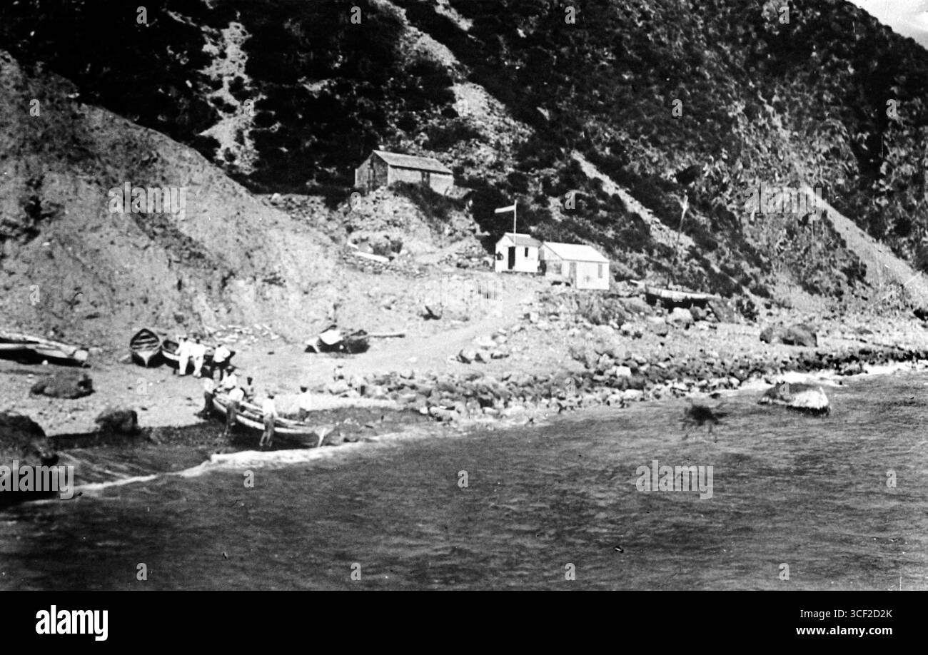 Questo ripronegatief del 1920-1950 mostra una spiaggia di sbarco per barche a remi, utilizzata per trasportare passeggeri e merci da e verso le navi più lontane in mare, illustrando le pratiche di trasporto marittimo dell'epoca. Foto Stock