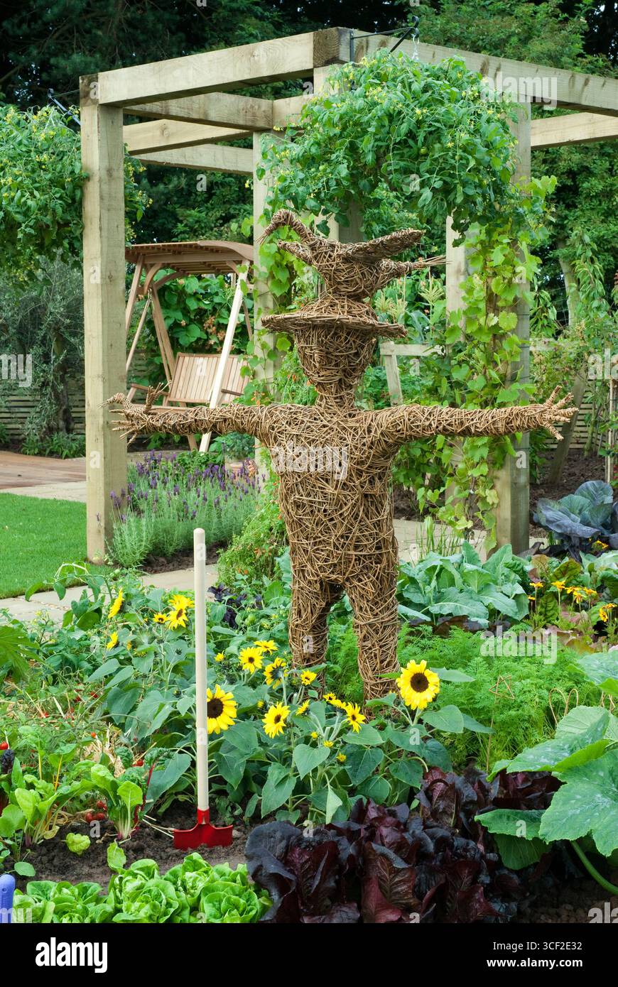 WICKER MAN IN VEGETAL BORDER, LATTUGA LITTLE GEM, RADDISH CHERRY BELLE, LATTUGA MARSHALL, ZUCCHINE OTTO BALL, CHIP DI CIOCCOLATO DI GIRASOLE, COLZA DI MONTONI Foto Stock