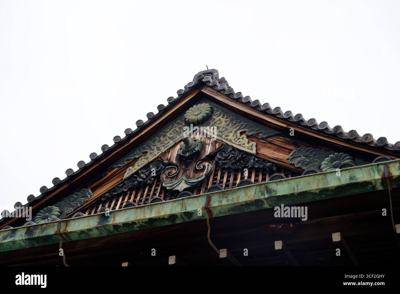 Timpano intempestivo del Castello Nijo adornato da intricate incisioni e tradizionali tegole giapponesi Foto Stock