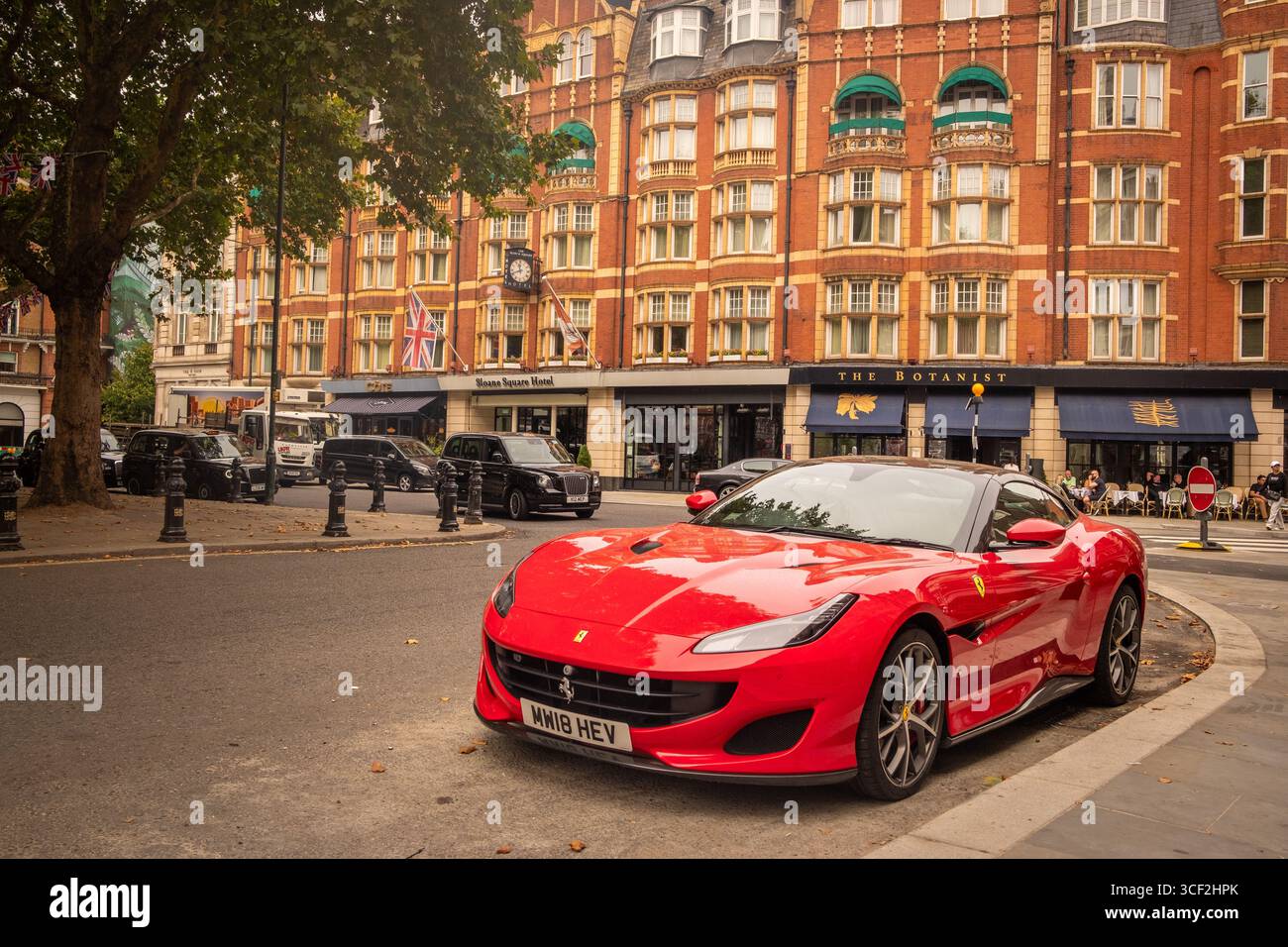 LONDRA - 13 AGOSTO 2025: Ferrari rossa parcheggiata su Sloane Square, una destinazione esclusiva per negozi e ristoranti. Foto Stock