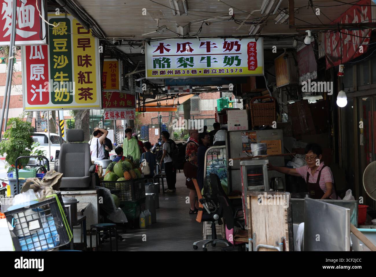 TAIPEI, TAIWAN. 1° GIUGNO 2025. I venditori preparano succhi di frutta freschi e tè al latte mentre la gente del posto si riunisce in una tradizionale bancarella di strada, riflettendo il vibr di Taiwan Foto Stock