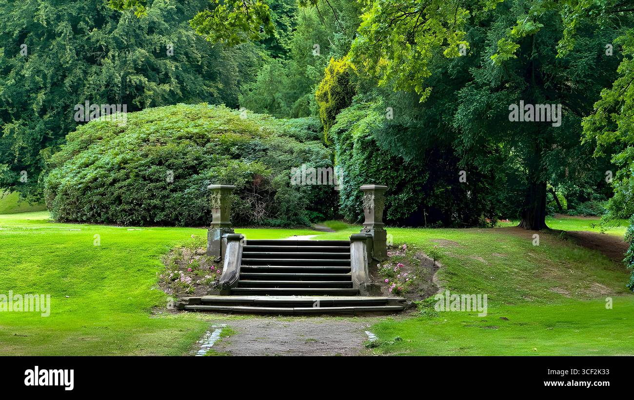 Gradini e pilastri in pietra che conducono a un lussureggiante paesaggio verde nel cimitero di Ohlsdorf, il più grande cimitero del parco del mondo ad Amburgo, in Germania. Foto Stock