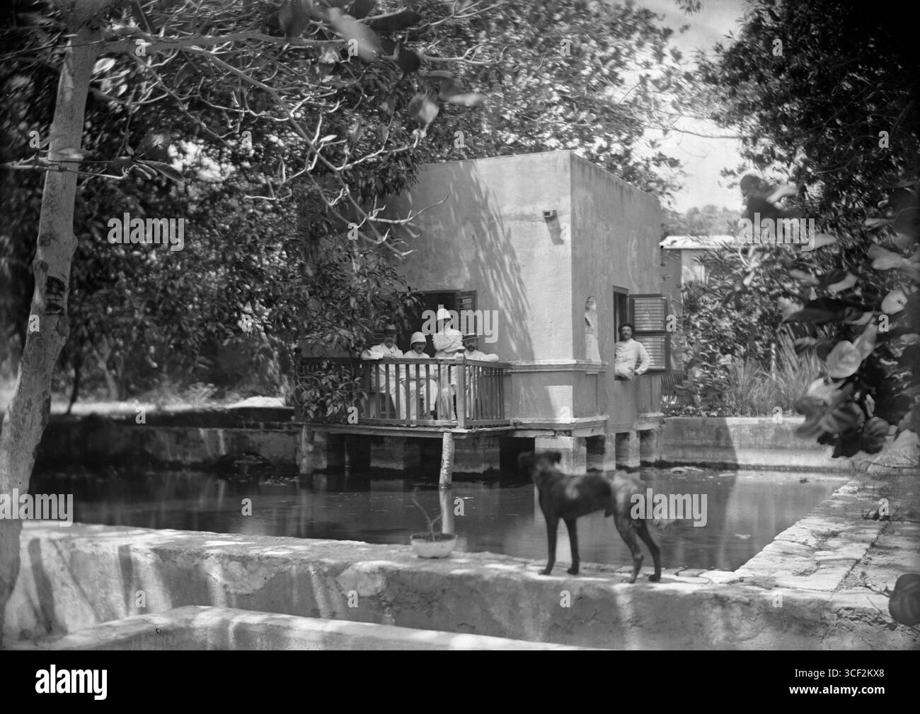 Questa foto mostra un gruppo di uomini all'interno di una casa circondata dall'acqua, probabilmente a causa di inondazioni o di un ambiente a base d'acqua. La foto è stata scattata tra il 1910 e il 1940 da un fotografo sconosciuto. Foto Stock