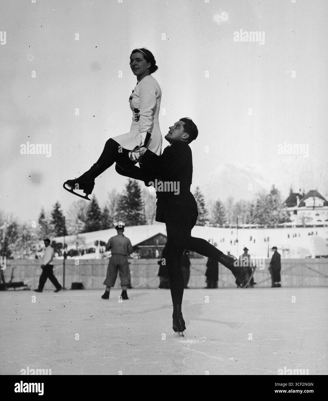 Emília Rotter e László Szollás eseguono un passaggio durante una sessione di allenamento alle Olimpiadi invernali del 1936 a Garmisch-Partenkirchen, Germania. Questo momento cattura la precisione e la forza necessarie per il pattinaggio artistico a coppie. Foto Stock