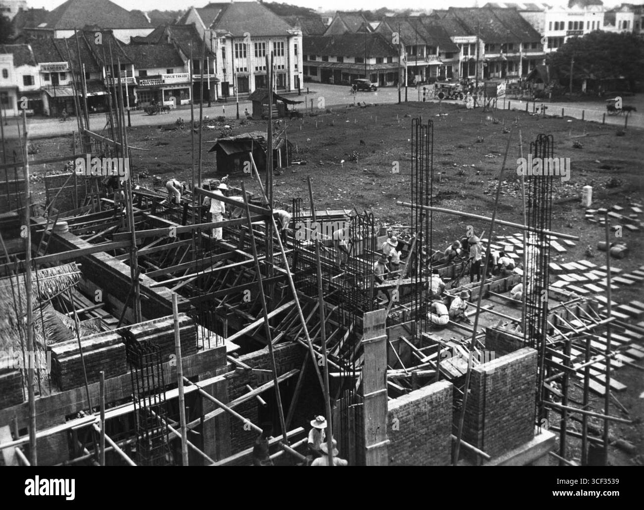 Una foto del 25 ottobre 1928, che mostra la costruzione del baldacchino per l'edificio anteriore della stazione ferroviaria di Jakarta Kota, con le case del quartiere cinese sullo sfondo. Foto Stock