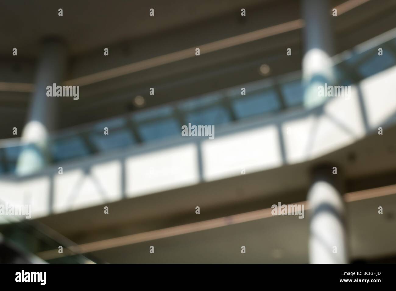 Una vista sfocata che mette in mostra elementi architettonici moderni, tra cui pilastri e luce naturale, creando una composizione astratta sorprendente. Foto Stock