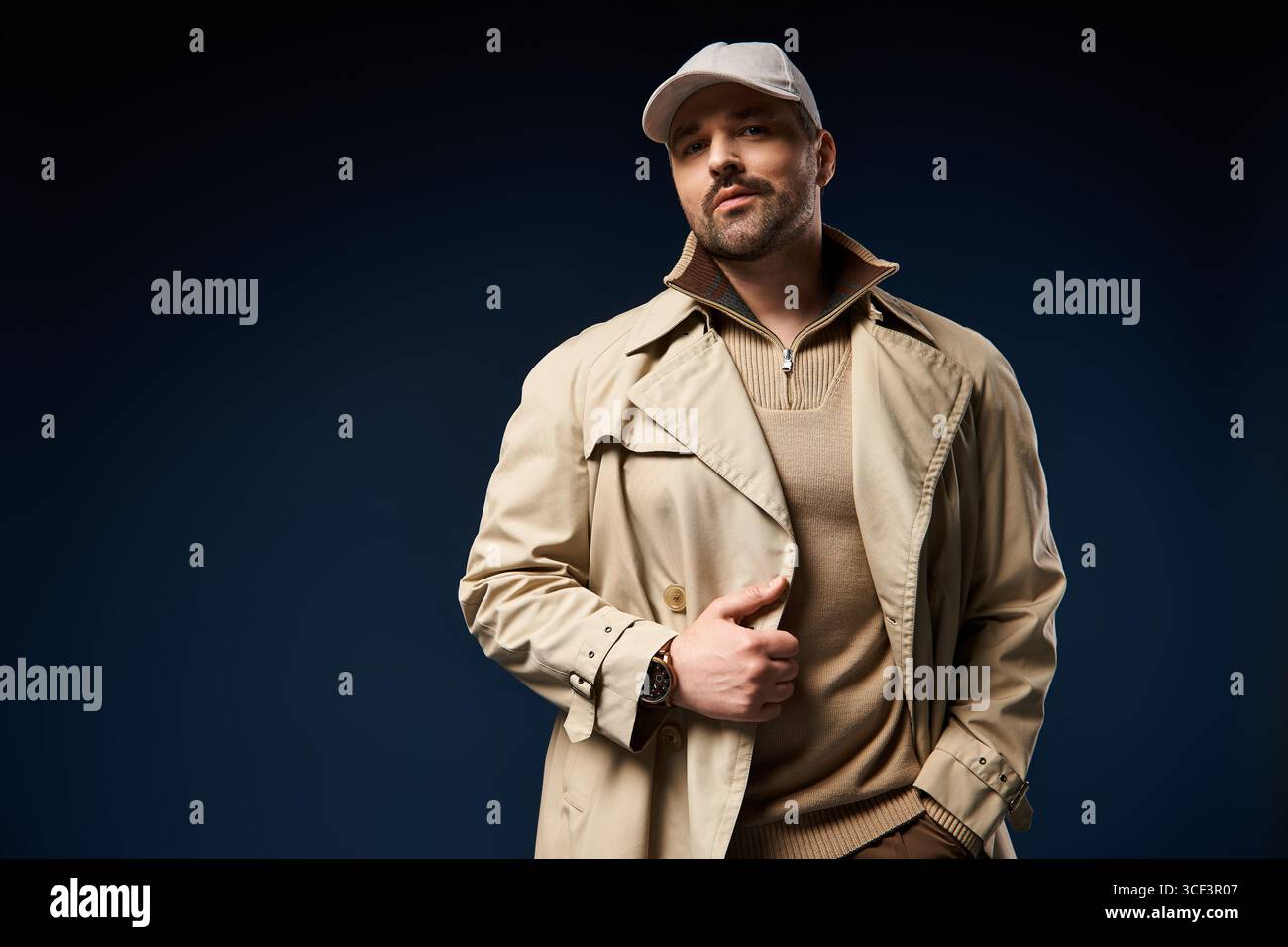Un uomo alla moda si pone con fiducia, mostrando le tendenze della moda moderna con eleganza. Foto Stock