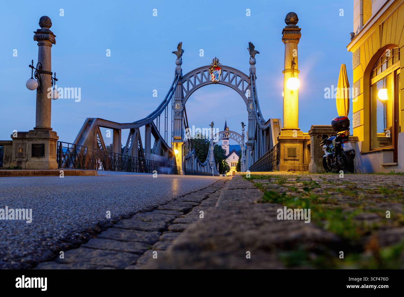 Ponte di campagna di Laufen an der Salzach in Berchtesgadener Land in alta Baviera, Baviera, Germania con vista sulla chiesa parrocchiale di San Nicola a Oberndorf vicino a Salisburgo, Salisburgo, Austria alla luce della sera Foto Stock