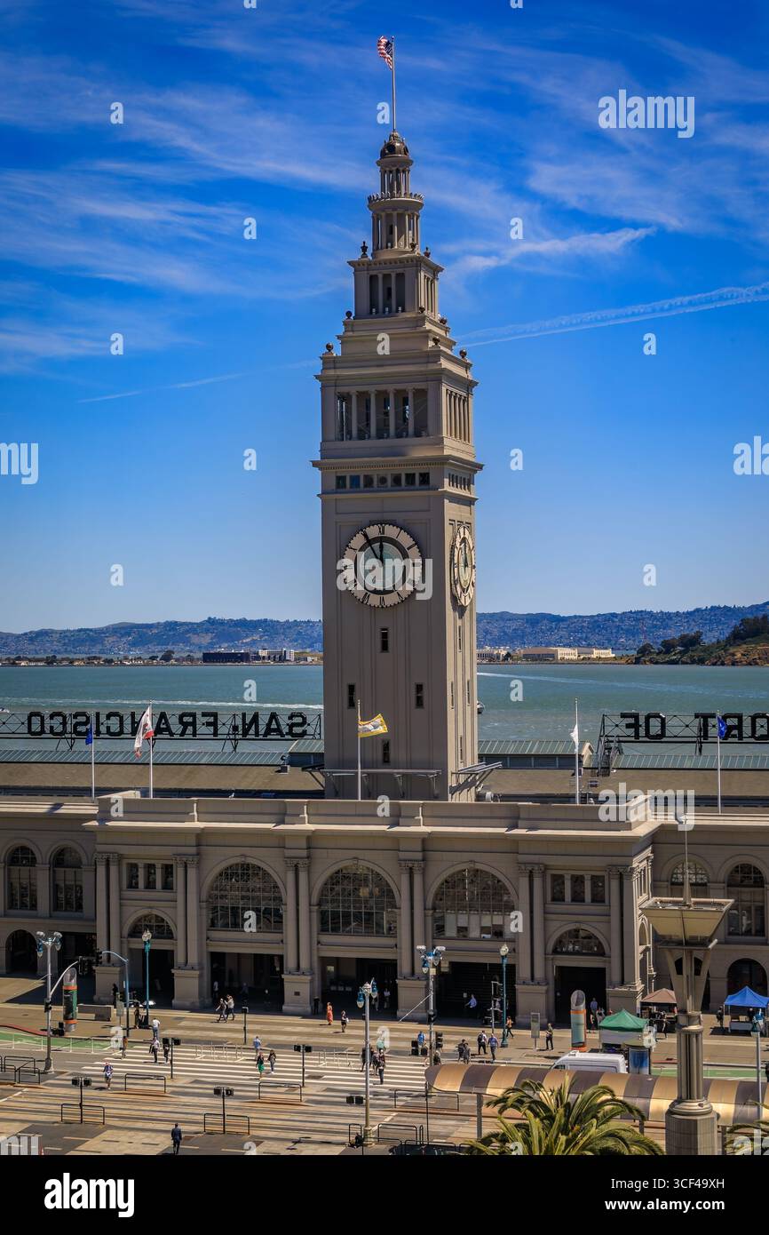 Lo storico Ferry Building con la sua iconica torre dell'orologio e le palme si erge sul lungomare di San Francisco a San Francisco, Stati Uniti Foto Stock