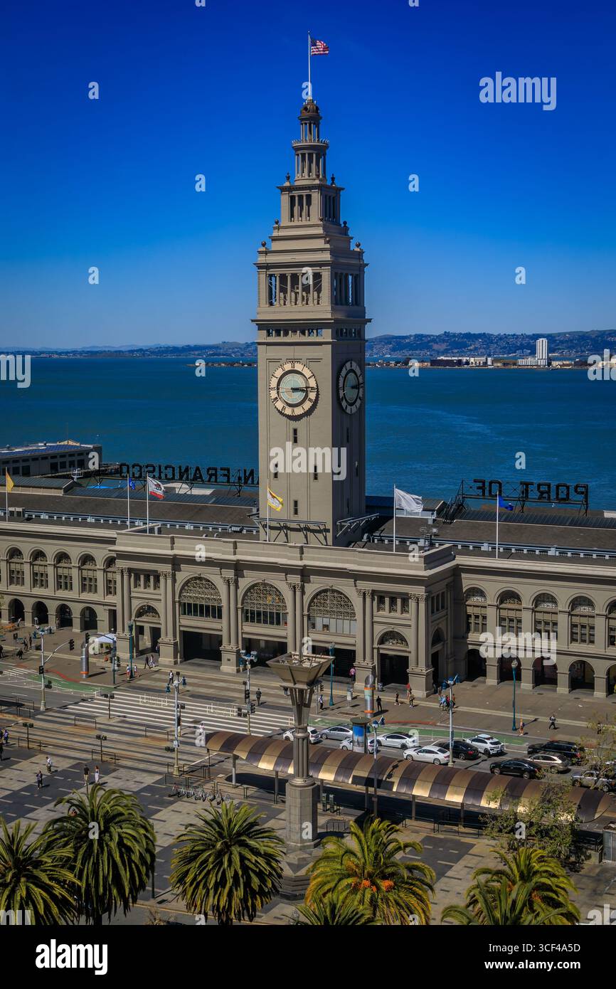 Lo storico Ferry Building con la sua iconica torre dell'orologio e le palme si erge sul lungomare di San Francisco a San Francisco, Stati Uniti Foto Stock