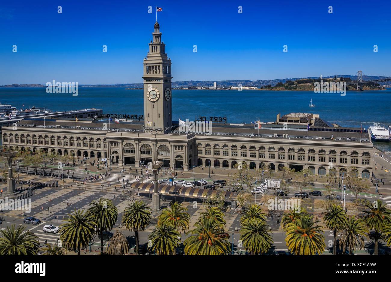 Lo storico Ferry Building con la sua iconica torre dell'orologio e le palme si erge sul lungomare di San Francisco a San Francisco, Stati Uniti Foto Stock
