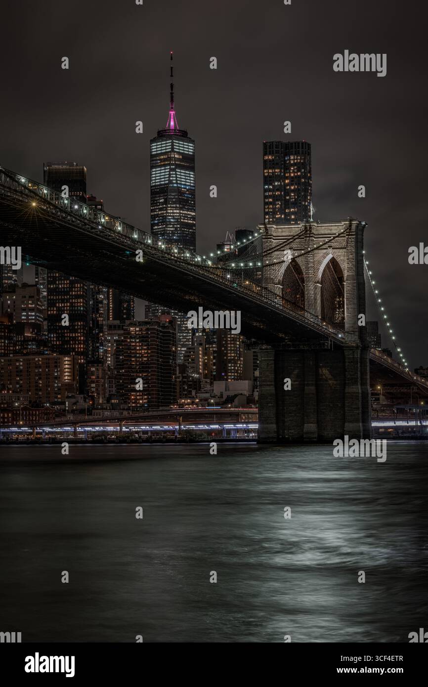 Ponte di Brooklyn e One World Trade Center illuminati di notte Foto Stock